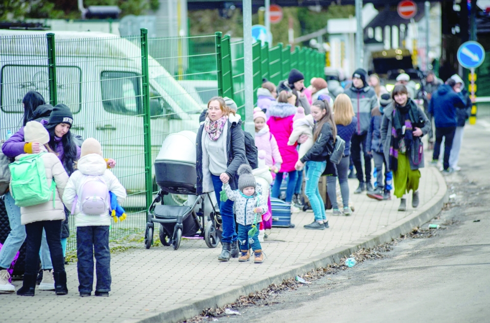 Thousands cross borders out of Ukraine, men told to stay and fight