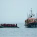Boat with hundreds of migrants safely towed to port